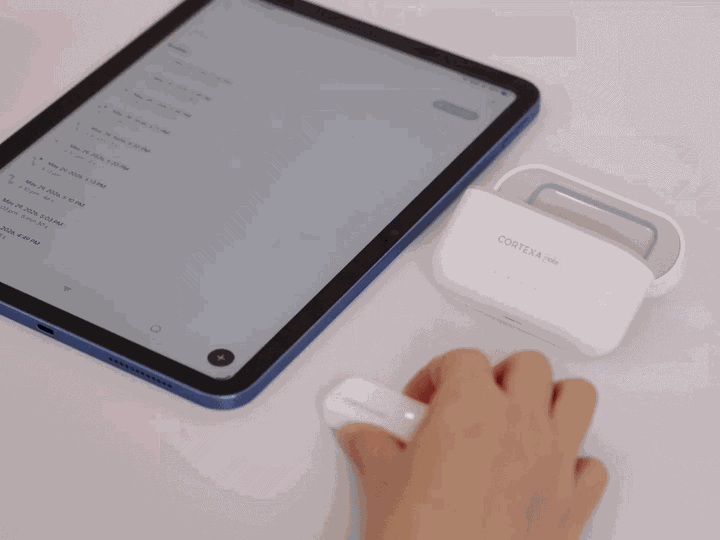 Hands placing the CortexaNote Recorder into its charging case